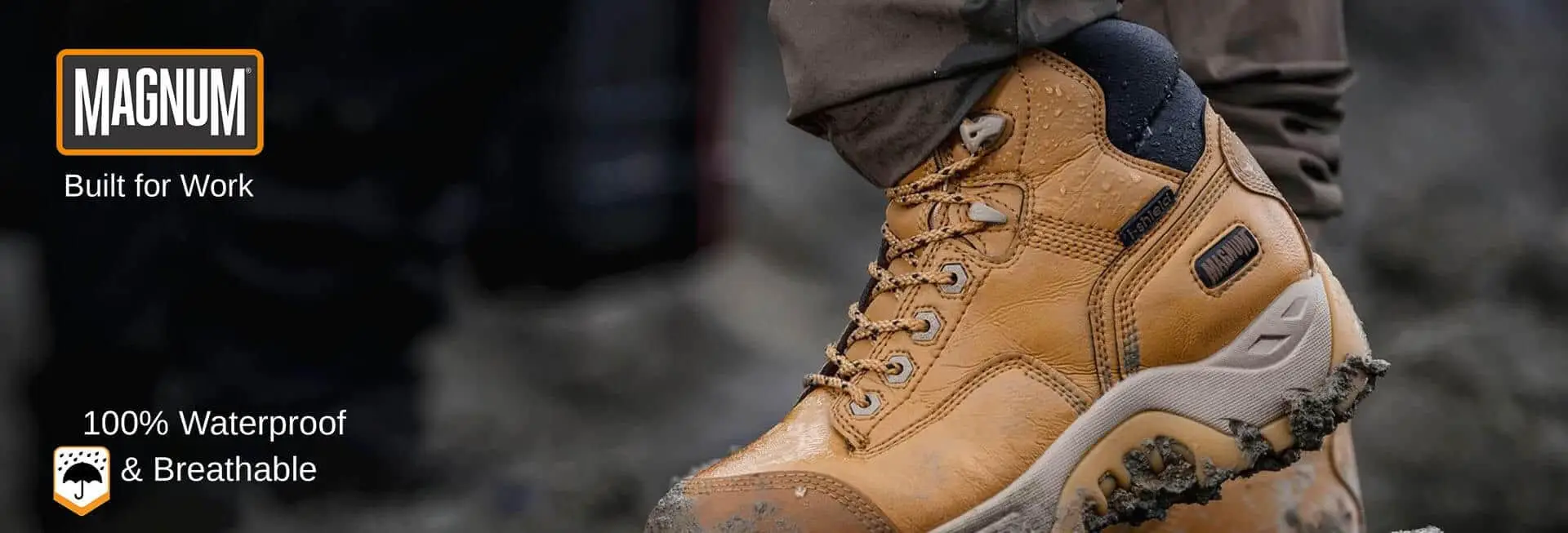 Close-up shot of a personโs leg and shoe, featuring a rugged tan work boot, laced up and resting on a surface, indicating durability and functionality in a work environment.