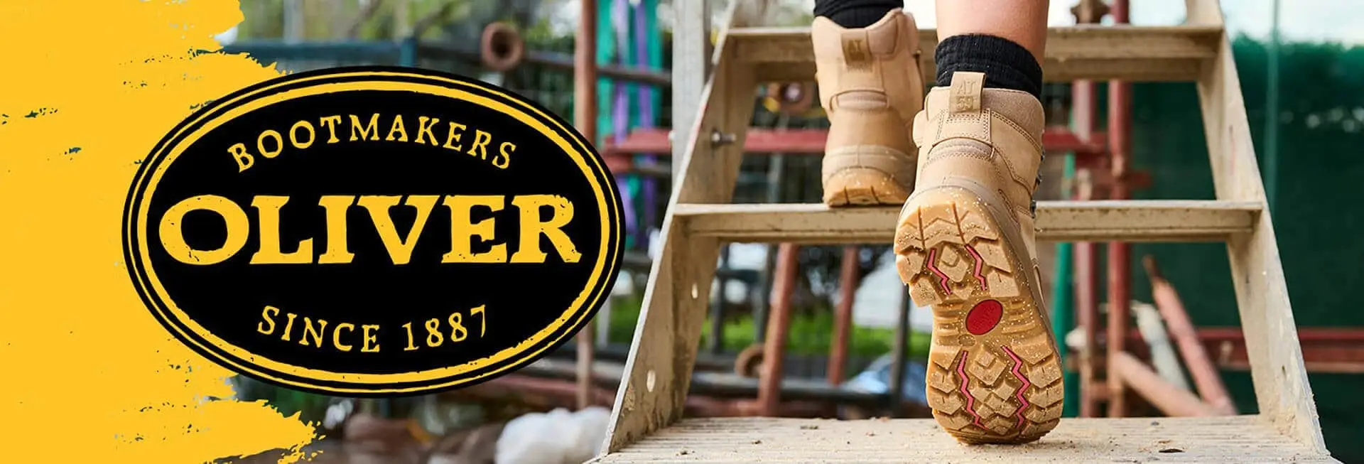 Image of a pair of tan work boots on a wooden ladder step, with a circular logo on the left featuring the brand name "TIMBER," established in 1887. The background shows colorful playground equipment.